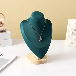 Detail of dark green velvet necklace bust stand with solid wood base and snowflake pendant
