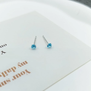 Macro detail of sky blue cubic zirconia stud earrings in four-prong silver setting