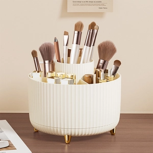Rotating cream makeup brush holder with gold legs and divided slots for cosmetics