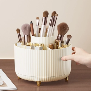 Rotating 360 cosmetic organizer with vertical stripes and gold legs for brushes and lipsticks