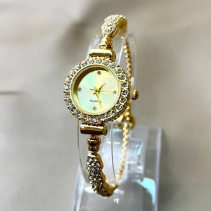 Detailed macro of gold quartz watch with rhinestones on a display stand
