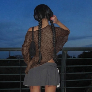 Detail of sheer brown lace texture on a French style asymmetric off-shoulder knit top