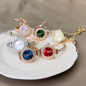 Detail of six elegant quartz bracelet watches with rhinestone bezels in a ceramic dish