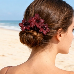 Elegant wine red flower claw clip for women styled on hair with a beach background