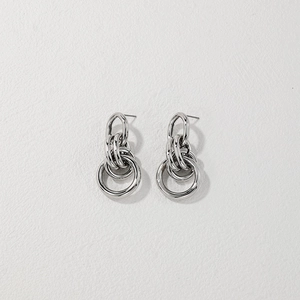 Detail view of silver multi-layered nested metal hoops on minimalist stud earrings