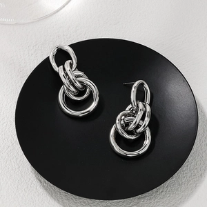 Close-up of silver metal multi-link hoop earrings with a modern industrial design finish
