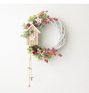 Detail of Christmas willow wreath with wooden birdhouse, pine cones and berries decoration