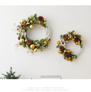 Detail of DIY Christmas wreaths with pine cones and golden ornaments on white willow rings