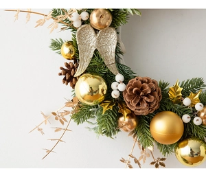 Detailed view of Christmas wreath featuring gold ornaments, pine cones and angel wings
