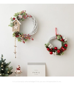 Detail of Christmas willow wreaths with wooden birdhouse and festive red berry ornaments
