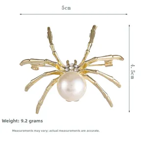 Dettaglio della spilla a ragno con addome perlato e accenti di strass scintillanti