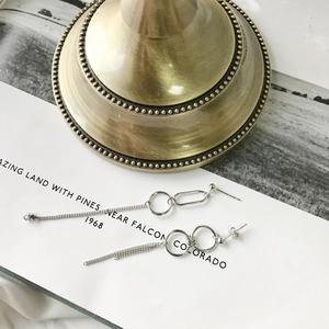 Detail view of asymmetric S925 sterling silver hoop earrings with chain elements