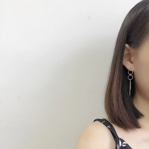 Detail of silver long tassel earrings with interlocking circles worn on a model
