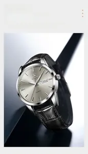 Gros plan d'une montre OLEVS avec cadran gris radial et affichage de la double date