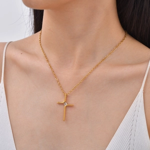 Close-up view of minimalist gold cross necklace with AAA diamond pendant on model