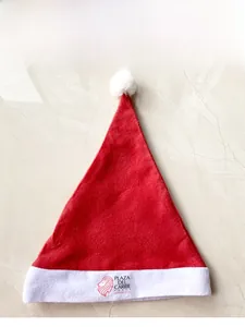 Detailed close-up of a red Christmas hat with white plush trim and custom logo area