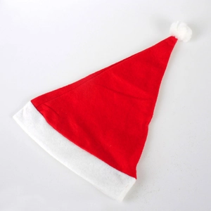 Detail of red felt Christmas hat with white plush trim and pompom on white background
