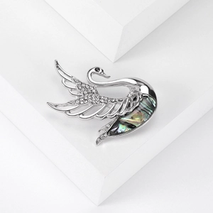 Detailed close-up of swan brooch with inlaid abalone shell and sparkling rhinestones