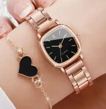 Close-up of a rose gold square dial watch paired with a black heart pendant bracelet