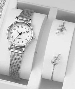Close-up of elegant women's quartz watch and sparkling silver leaf bracelets in a gift box