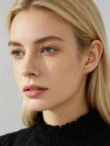 Detail of s925 sterling silver figure eight stud earrings on model ear with crystals