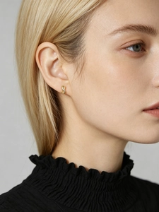 Close-up of elegant s925 silver infinity stud earrings with crystals on a female ear