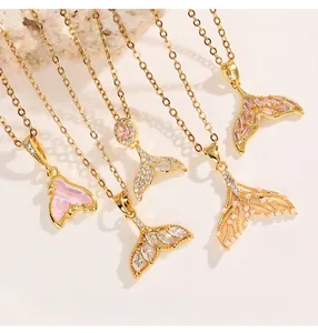 Detailed view of mermaid tail pendants featuring pink gems and premium gold plating