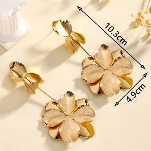 Detail of gold flower tassel earrings with dimensions of 10.3cm and 4.9cm on beige background