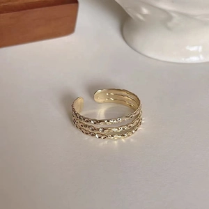 Detail of golden multi-layer open ring with hammered texture in a minimalist setting