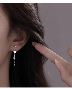 Detailed view of S925 sterling silver star tassel earrings worn on a model ear