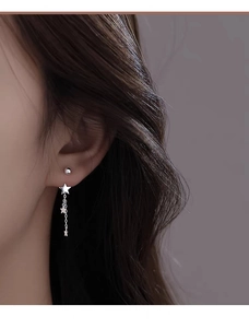 Close-up of S925 silver star tassel earrings worn on ear with dangling chain details