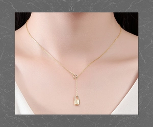 Detailed close-up of a gold star lock necklace with a crescent moon and pavé zirconia stones