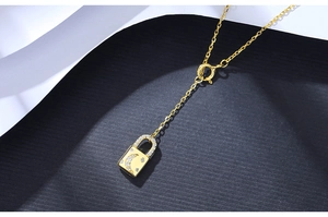 Macro shot of gold star and moon lock pendant necklace with sparkling cubic zirconia inlay