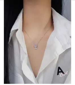 Close-up of a silver pavé-set kitten pendant necklace on a model's collarbone