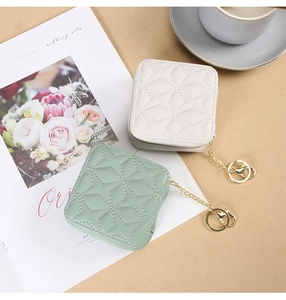 Detail view of mini quilted lipstick bags with star stitching and gold zipper chains