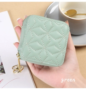 Mini mint green quilted lipstick bag with gold hardware held in an elegant cafe setting