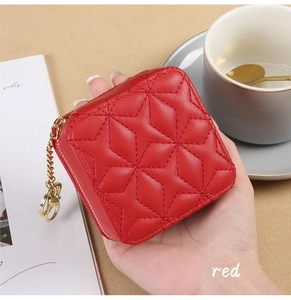 Detail shot of mini red quilted lipstick bag with gold chain and star stitching