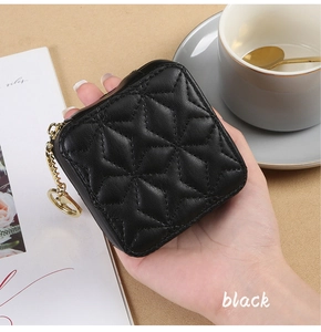 Close-up of black quilted mini lipstick bag with gold chain and star stitching detail