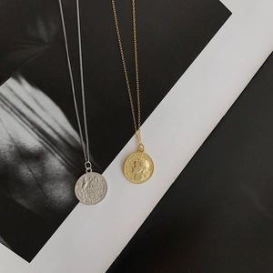 Detailed close-up of S925 sterling silver French coin pendants in gold and silver finish