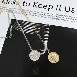 Detailed view of S925 sterling silver coin pendants in gold and silver on a magazine