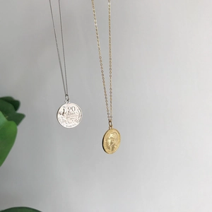 Detailed macro view of S925 sterling silver coin pendants with 1951 Francs engraving