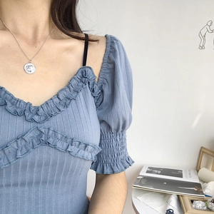 Detail of S925 sterling silver coin pendant necklace styled with blue ribbed knit top