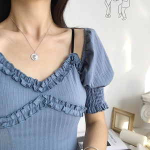Detail of S925 sterling silver coin necklace on blue striped knit top with ruffles