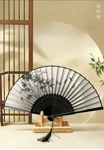 Chinese ink painting folding fan with bamboo and dragonfly design on a wooden stand