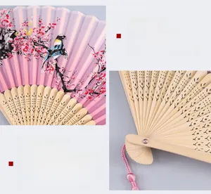 Detail of traditional Chinese folding fan with plum blossoms pattern and hollow carved ribs