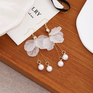 Detailed close-up of elegant white petal tassel earrings featuring pearl drops and gold hooks.
