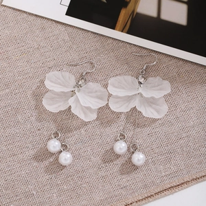 Close-up of elegant white petal tassel earrings with silver needles and pearl drops