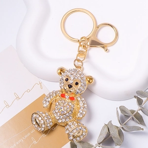 Close-up of sparkling rhinestone bear keychain with a red bow on a display stand