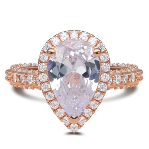 Macro detail of rose gold ring featuring pear-cut halo zircon and pavé setting