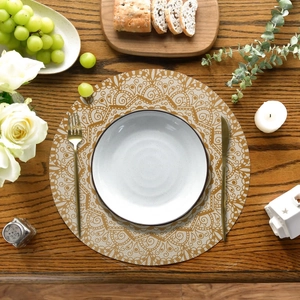 Bohemian style round linen placemat with gold mandala pattern on wooden table